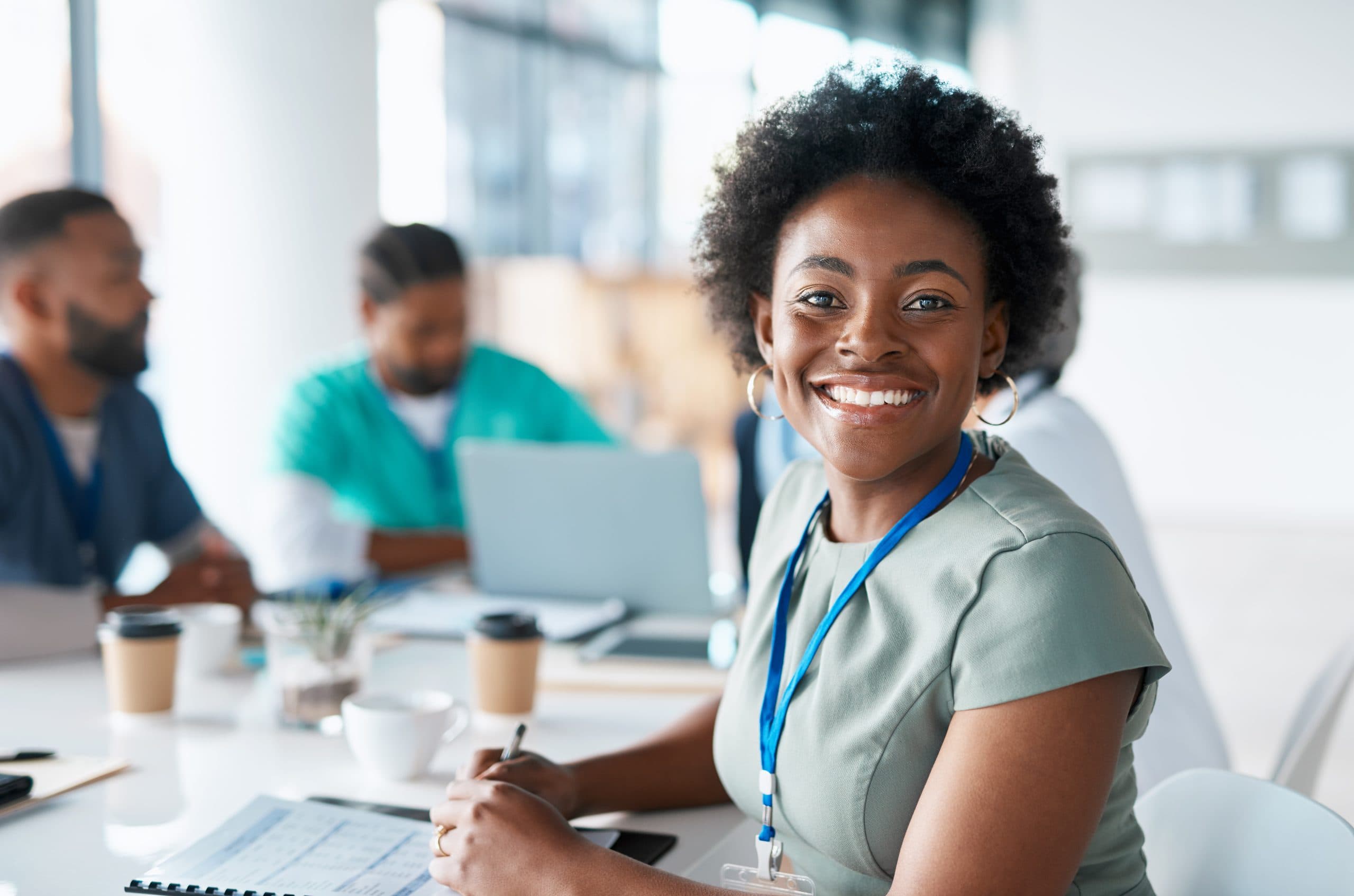 A healthcare professional with colleagues collaborating at a table