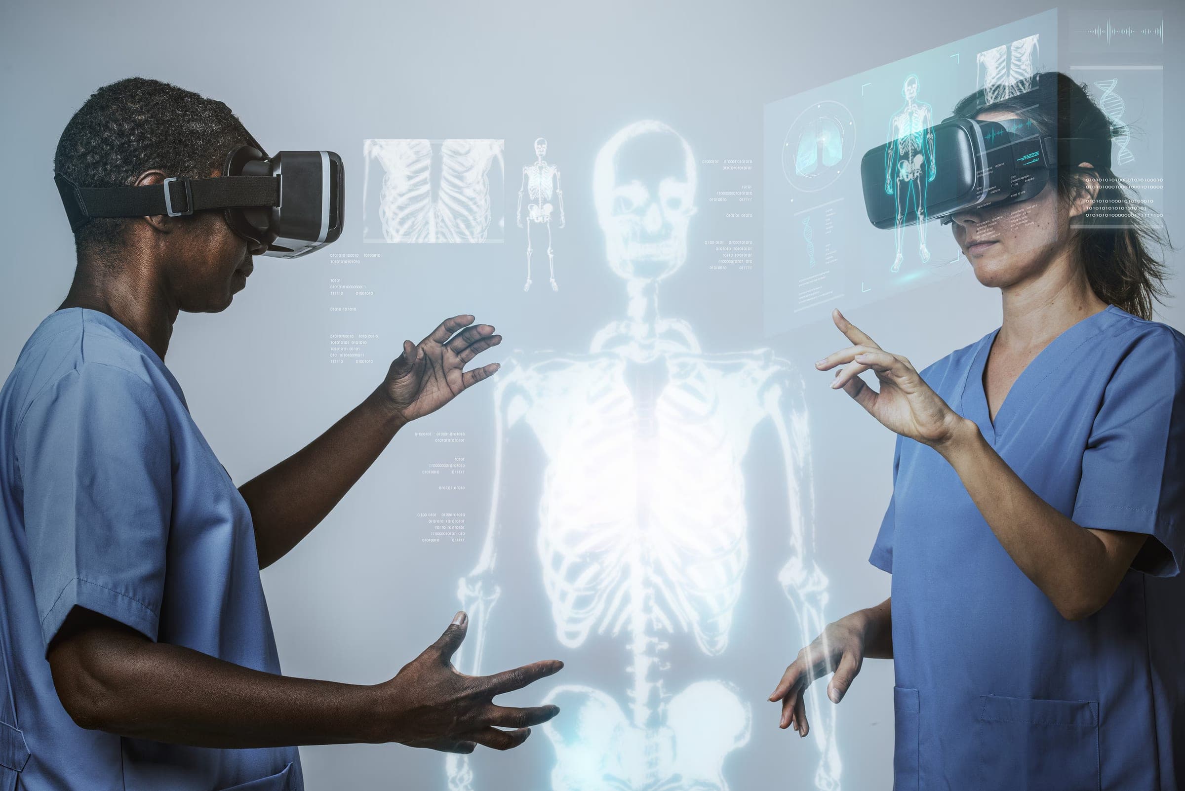Two clinicians in scrubs using headsets to study a holographic human skeleton
